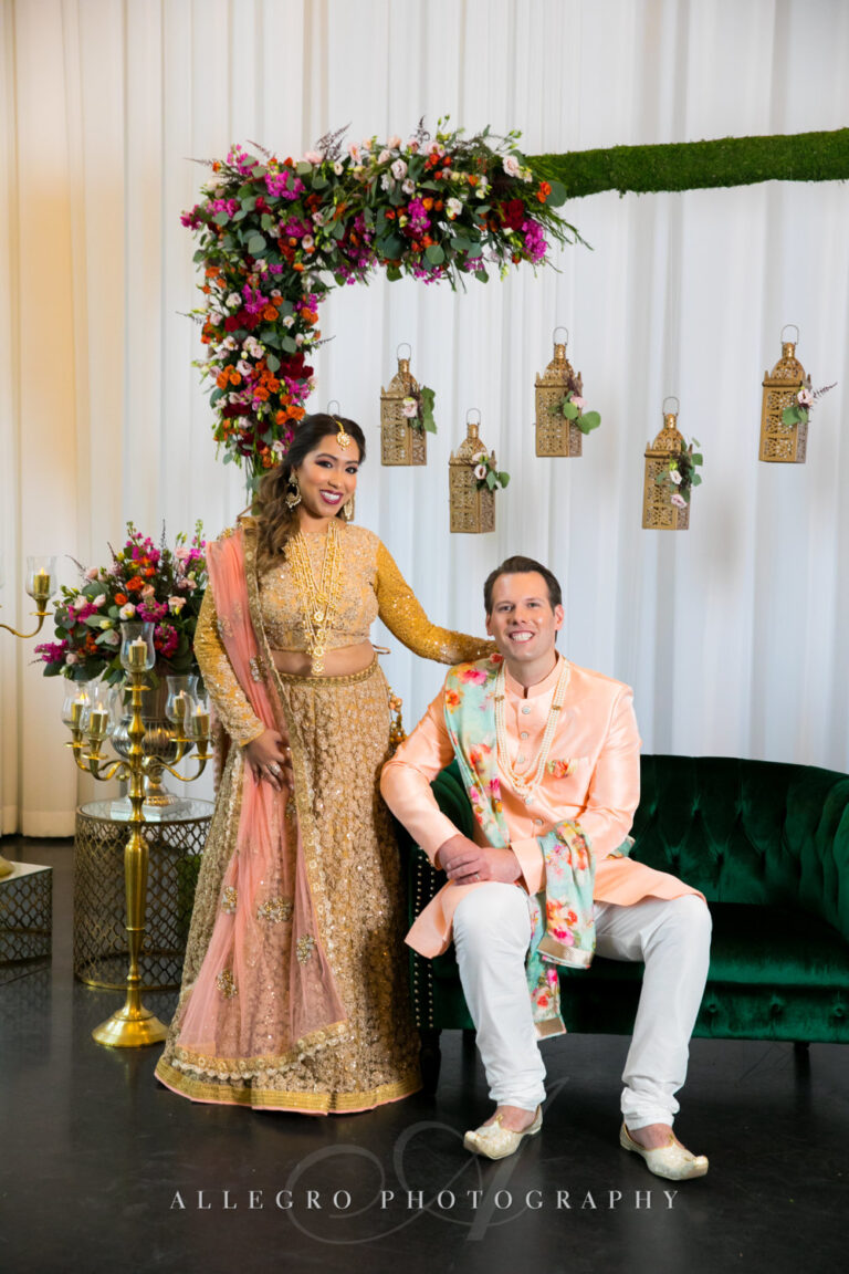 Couple posing beneath elegant floral décor during their wedding celebration at Lakeview Pavilion in Foxborough, Massachusetts.