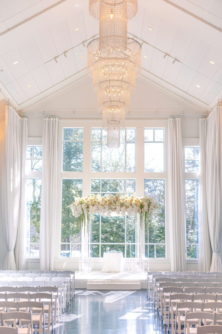 Elegant Chuppah ceremony setup in the Lakeside Ballroom at Lakeview Pavilion in Foxborough, Massachusetts, featuring floor-to-ceiling windows and abundant natural light.
