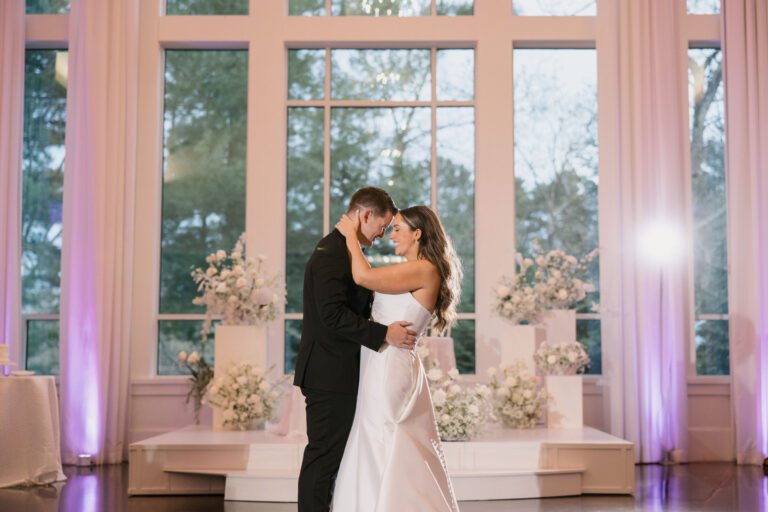 Bride and groom sharing a romantic embrace in the Lakeside Ballroom at Lakeview Pavilion in Foxborough, Massachusetts.