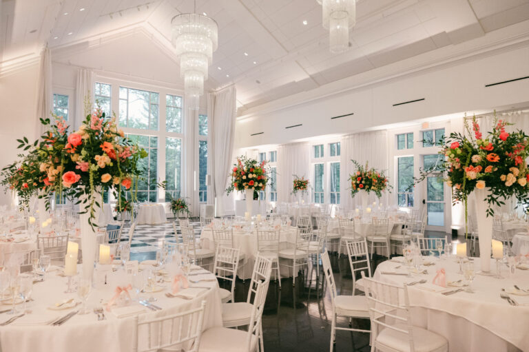 Elegant wedding reception in the Lakeside Ballroom at Lakeview Pavilion featuring soaring windows, romantic floral centerpieces, candlelit tables, crystal chandeliers, and a spacious dance floor in Foxborough, Massachusetts.