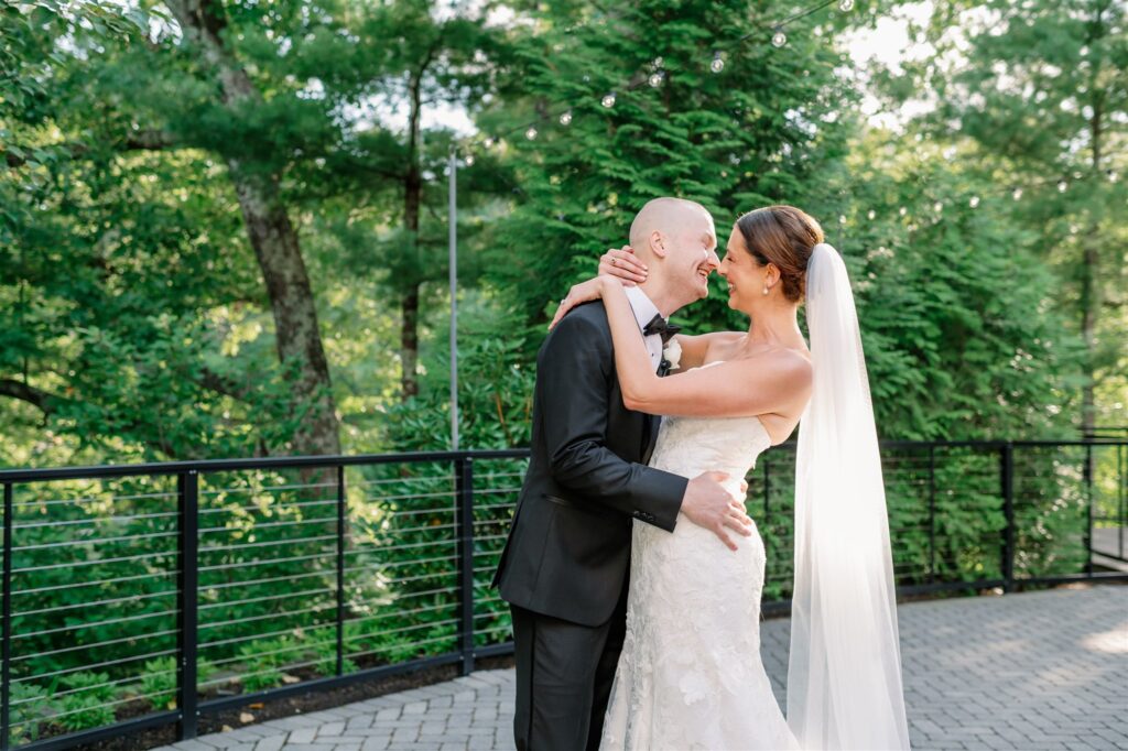 Bride and groom embracing on the private outdoor terrace outside the Lakeside Ballroom at Lakeview Pavilion in Foxborough, Massachusetts.