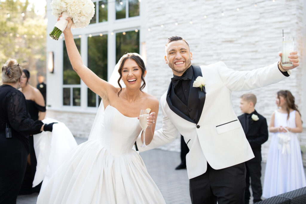 Bride and groom celebrating during cocktail hour on the private outdoor terrace outside the Lakeside Ballroom at Lakeview Pavilion in Foxborough, Massachusetts.