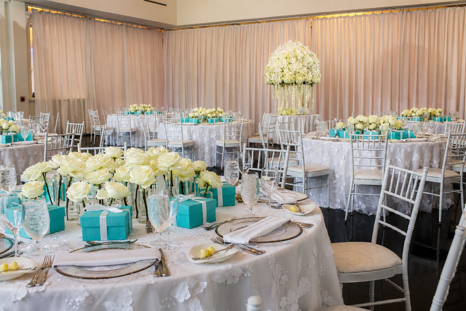 Elegant bridal shower reception setup at Lakeview Pavilion featuring white floral centerpieces, beautifully dressed tables, and a bright event ballroom in Foxborough, Massachusetts.